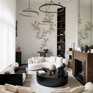 luxury living room with statement pendant lighting, curved sofa, fireplace, and modern decor