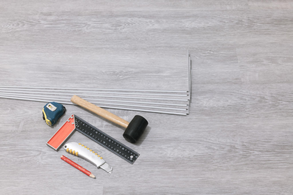 How to install hardwood floors with tools and planks laid out on a prepared surface