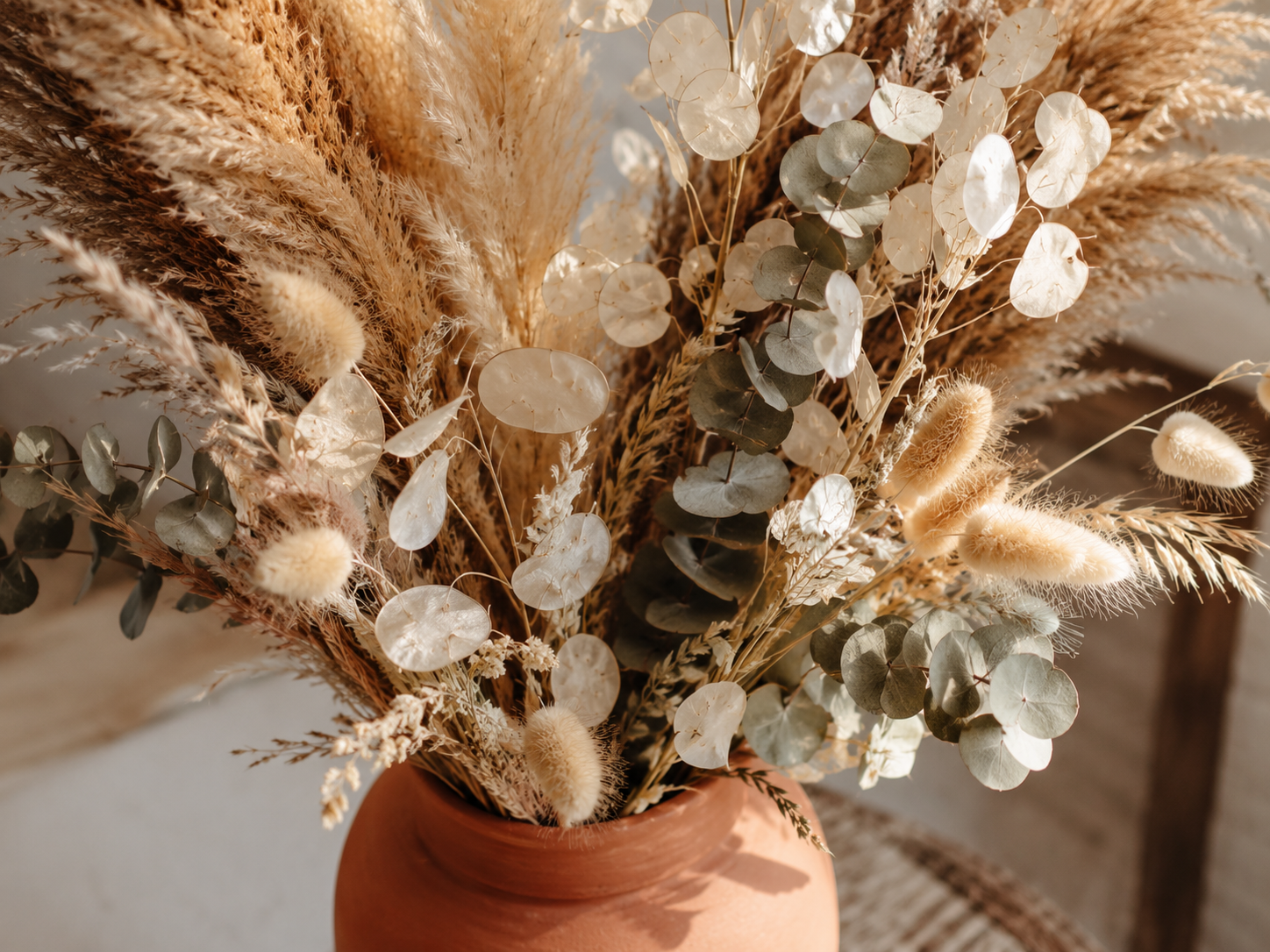 Close detail of a dried botanical arrangement in a ceramic vessel